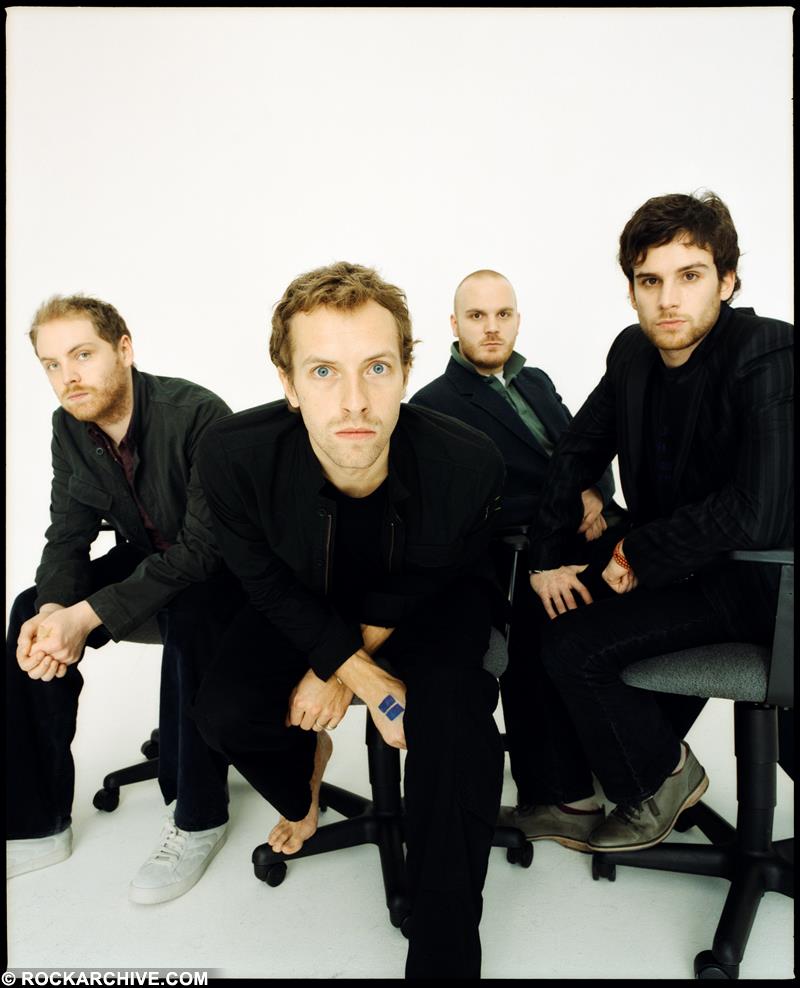 Colour limited edition print of Coldplay sat on office chairs shot by Jake Chessum in 2005.