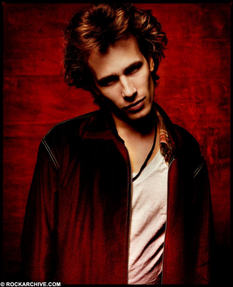 A limited edition colour print of Jeff Buckley wearing a red jacket and white shirt in 1993
