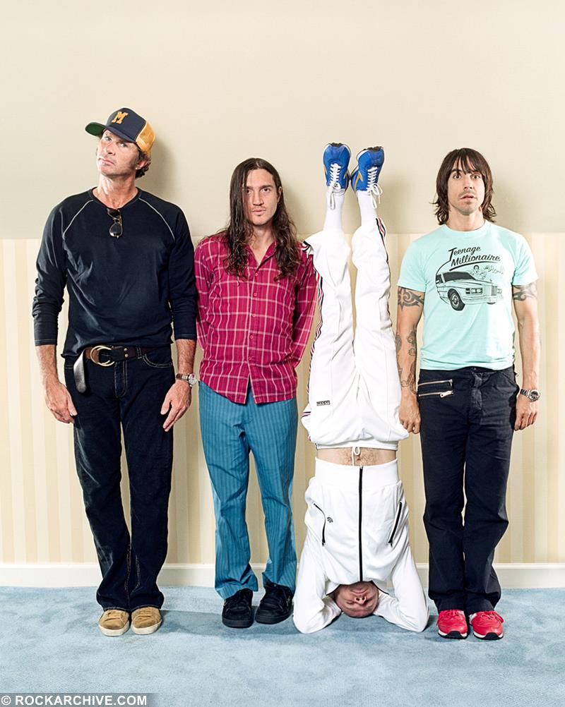 A limited edition colour print of the Red Hot Chilli Peppers against a wall.