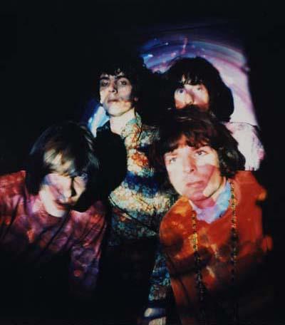 A Rockarchive limited edition colour print of the 1967 members of Pink Floyd illuminated by coloured lights.