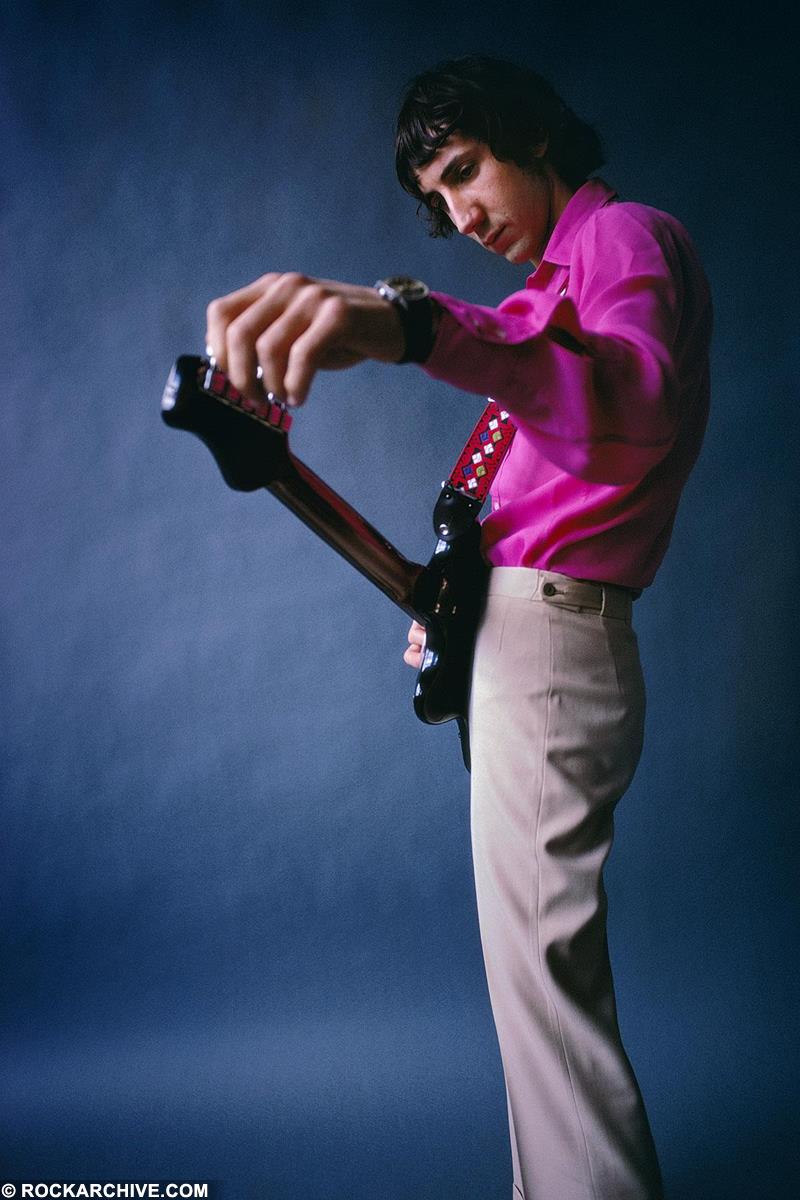 Pete Townshend wearing a pink shirt and holding his guitar in 1968.