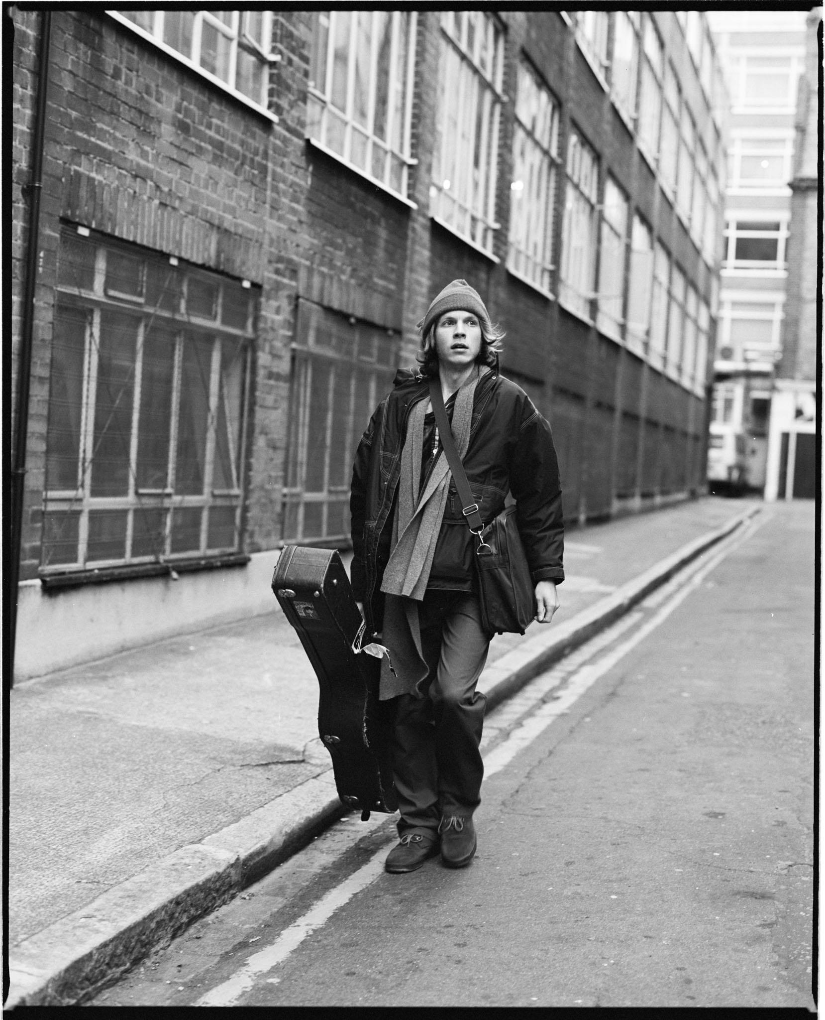 Limited edition print of Beck walking down a road holding a guitar in 1994.