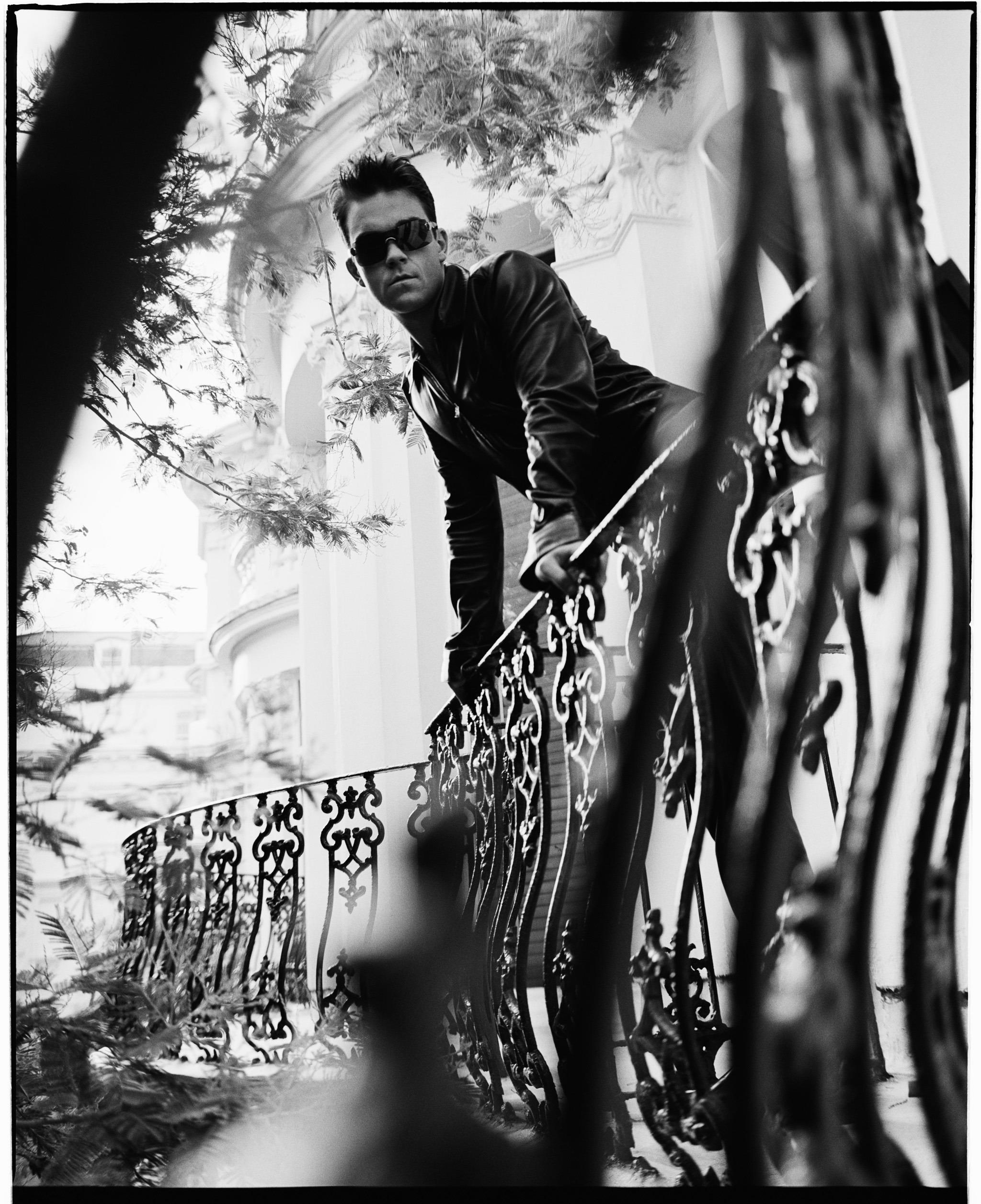 Limited editon print of Robbie Williams leaning over railings in 2000.