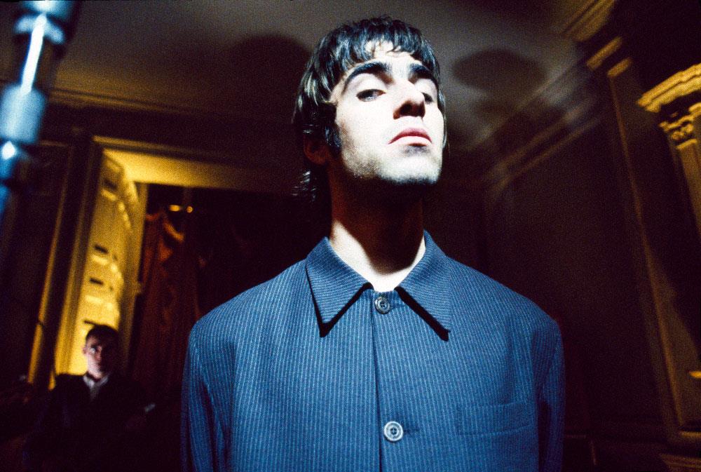 A limited edition Rockarchive print of Liam Gallagher from Oasis wearing a blue shirt and looking down his nose.