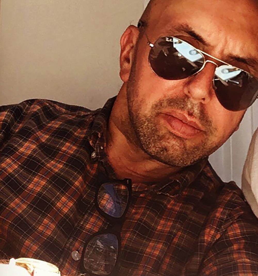 Photographer Pat Pope wearing a checked shirt and sunglasses.