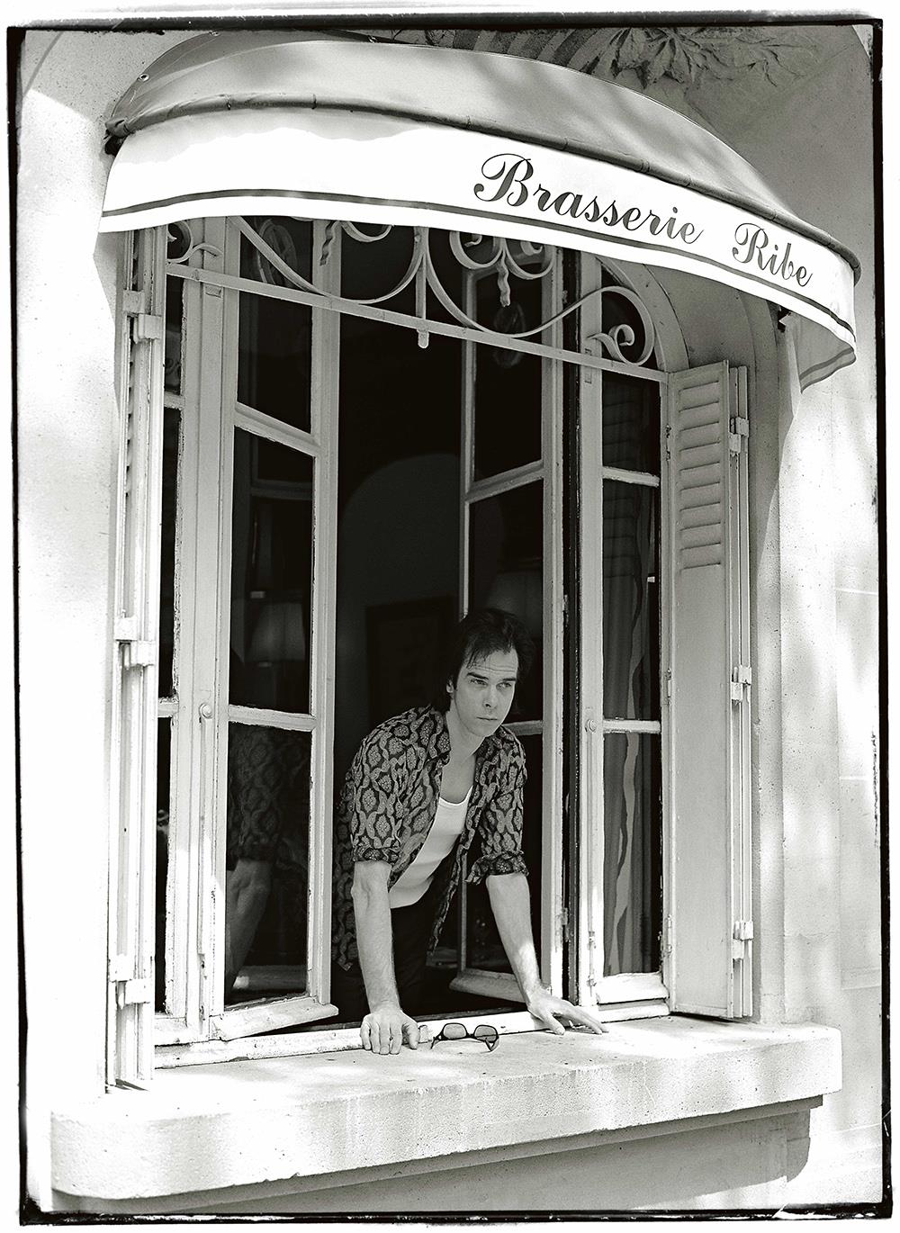 A limited edition print of Nick Cave looking through a window.