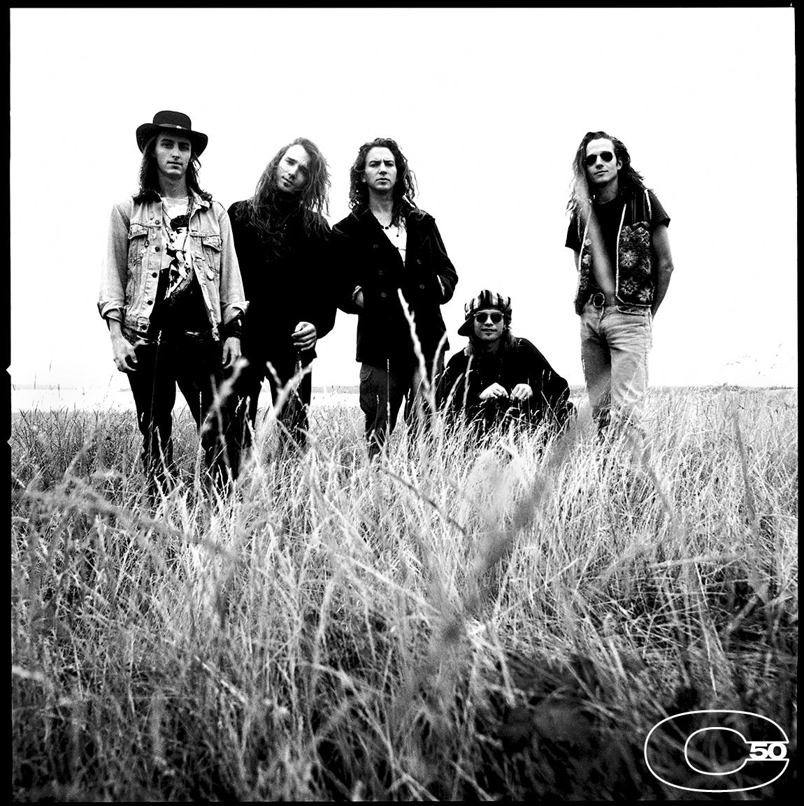 A limited edition print of Pearl Jam stood in long grass in 1991.