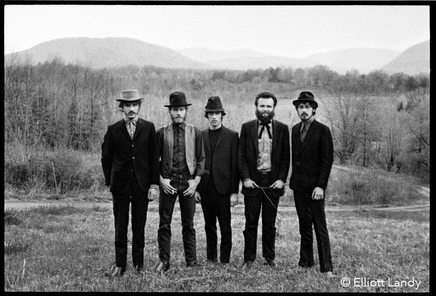 A limited edition print of The Band stood in a field with mountains behind them.