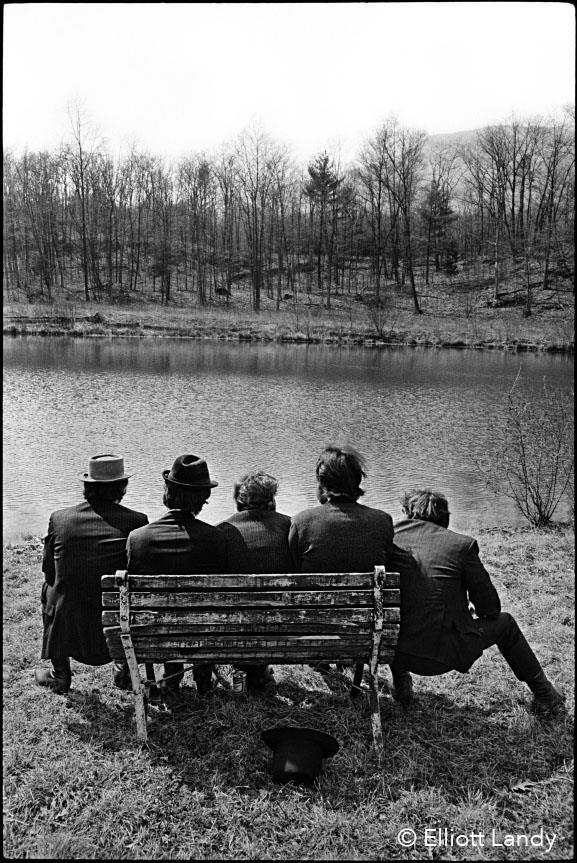 A limited edition print of The Band sat on a bench facing the lacke behind Big Pink.