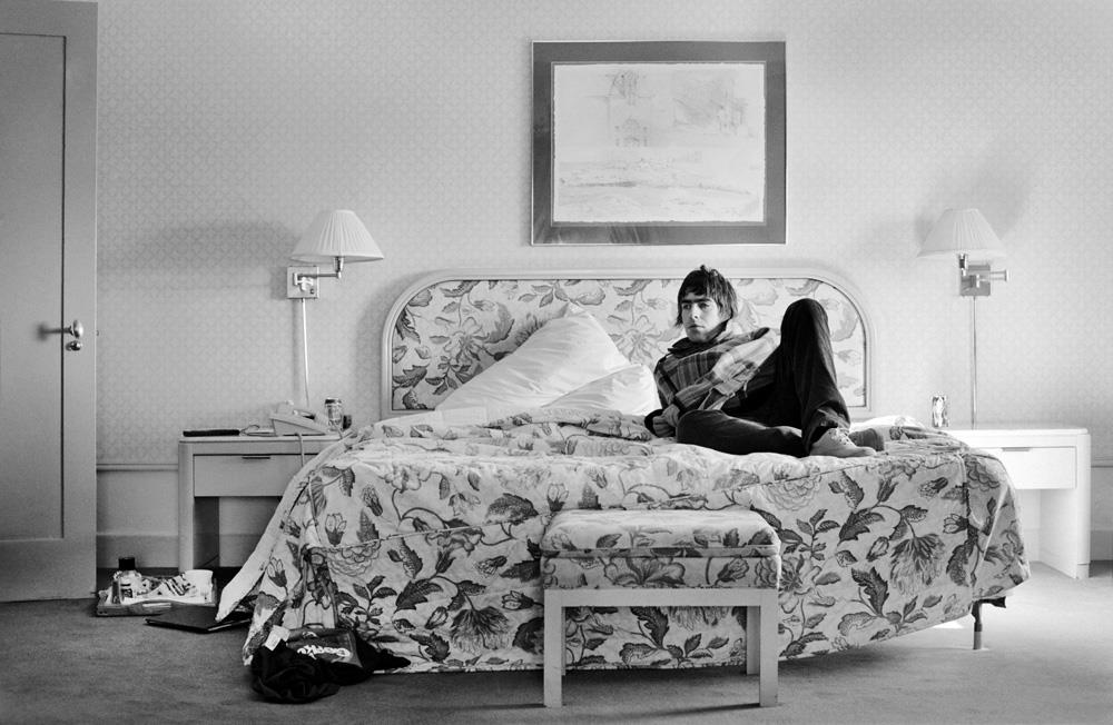 A limited edition print of Liam Gallagher sat on the bed in a US hotel room in 1996.