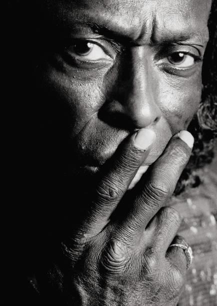 A limited edition print of Miles Davis with his hand over his mouth.
