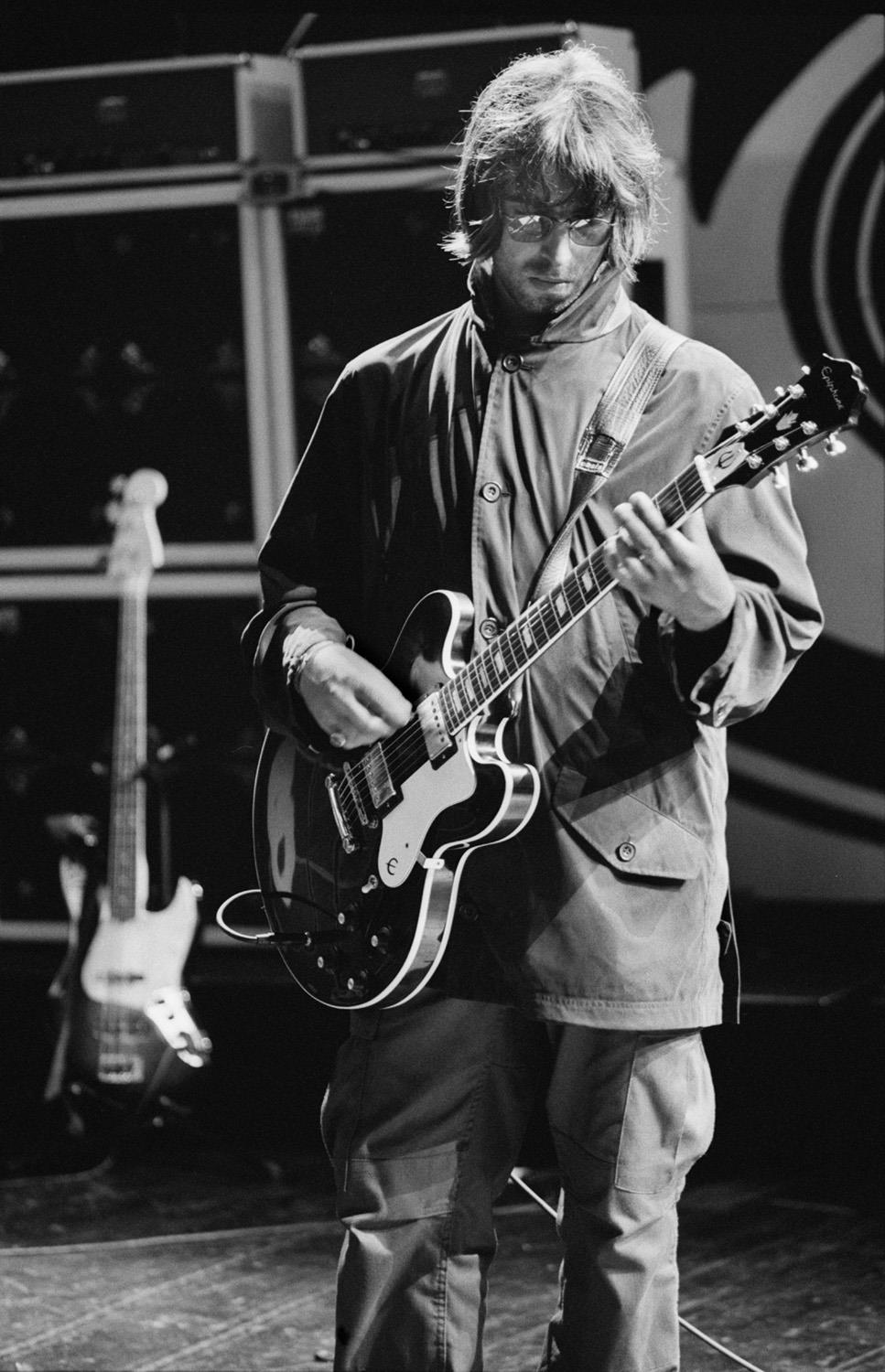 A limited edition Rockarchive print of Liam Gallagher playing guitar during Oass rehersals at the NEC in 1996.