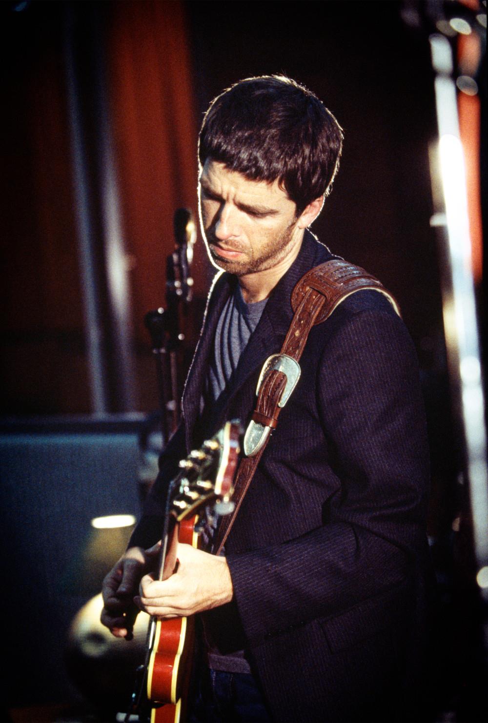 A limited edition colour print of Noel Gallagher playing guitar looking down in the Olympic Studio.