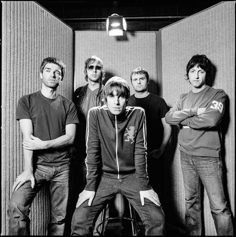 A limited edition print of Oasis standing together, posing while looking at the camera in Olympic Studios.